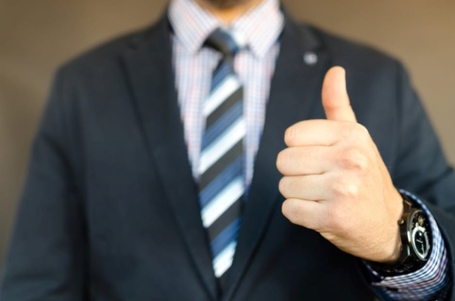 man in suit giving thumbs up sign