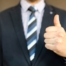 man in suit giving thumbs up sign