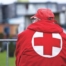 man wearing red cross jacket