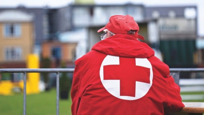 man wearing red cross jacket